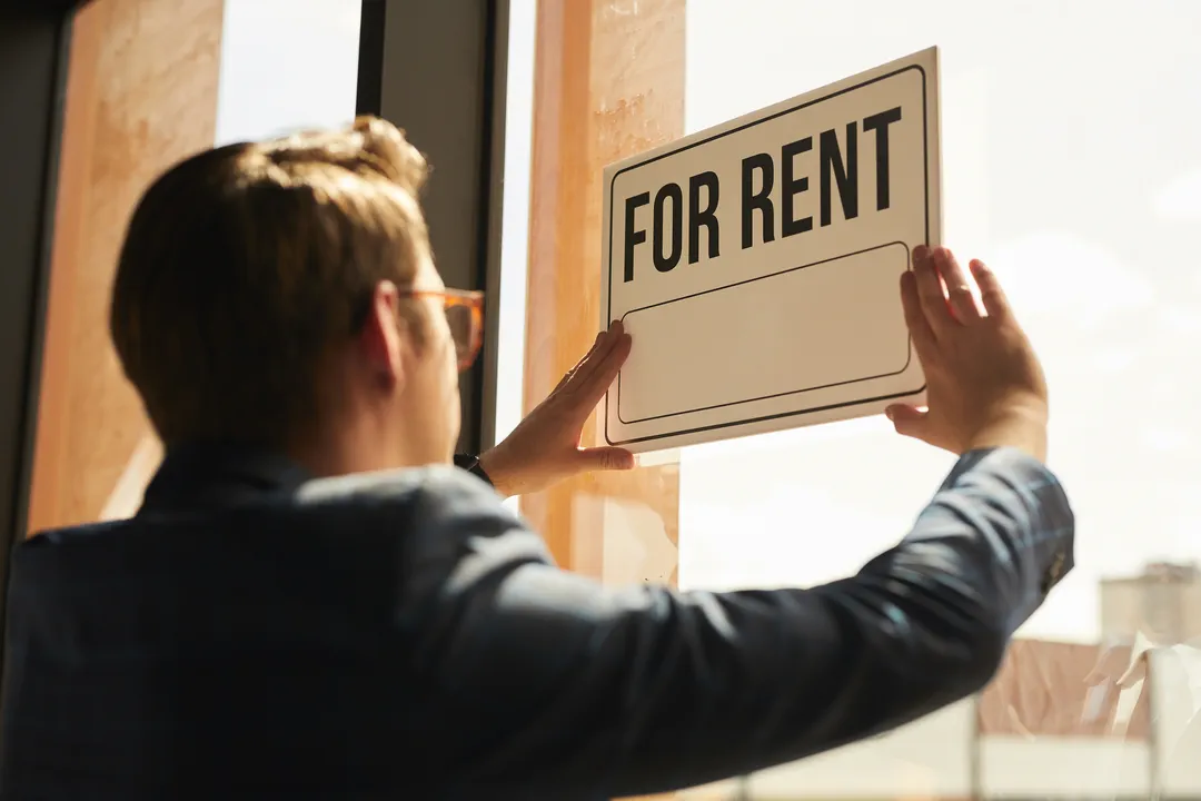 agent posting a "for rent" sign on a property